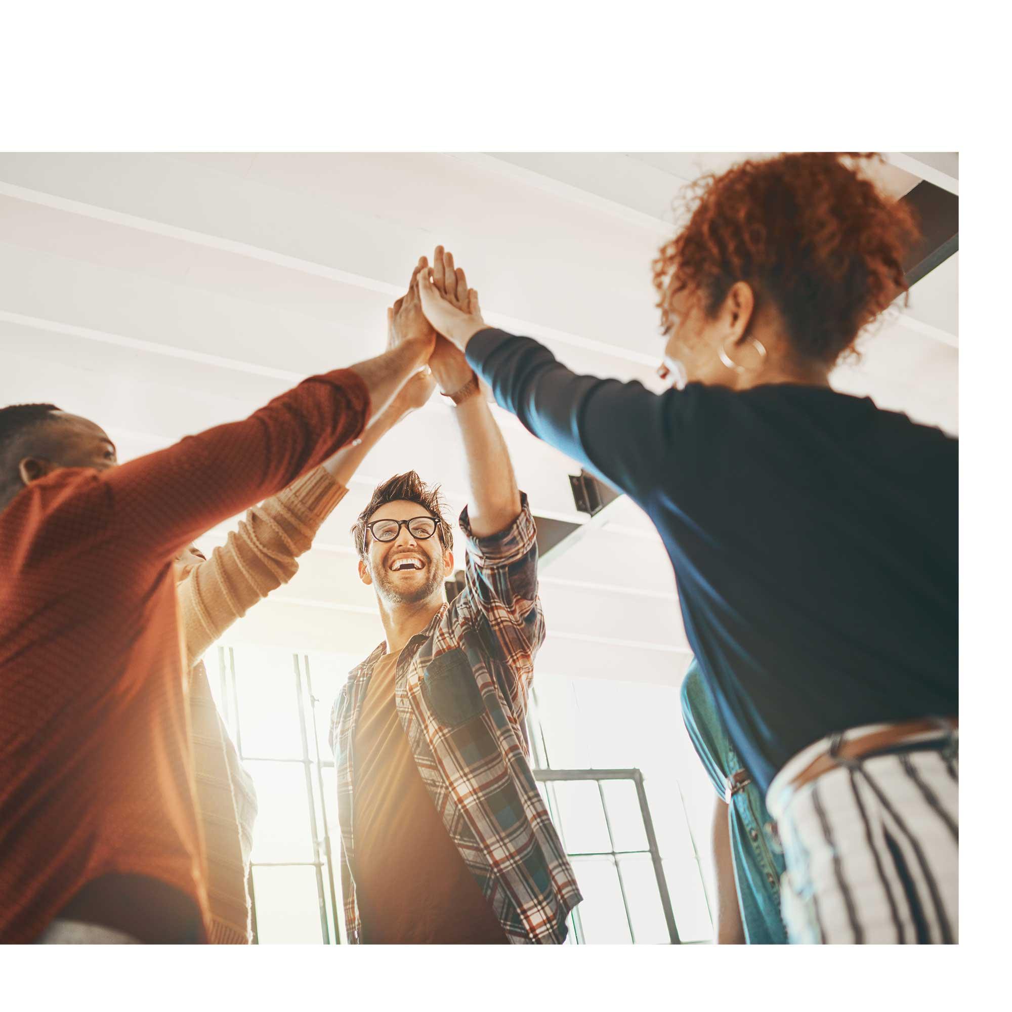 People putting their hands together to demonstrate teamwork.