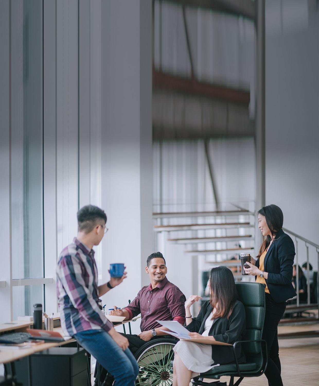 Group of four employees gathering to discuss CentralSquare resources and success stories